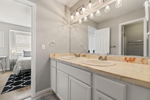 ein Badezimmer mit zwei Waschbecken und einem Spiegel in der Unterkunft Cypress Cottage in Charleston