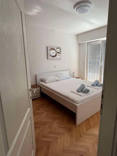 sypialnia z łóżkiem i zegarem na ścianie w obiekcie Rosana's Apartment w Ochrydzie