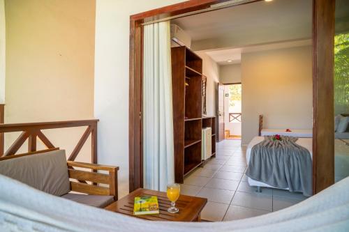 a room with a bed and a table and a mirror at Casa Suiça Brasileira in Jericoacoara