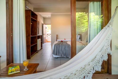 a hammock in a room with a bedroom at Casa Suiça Brasileira in Jericoacoara