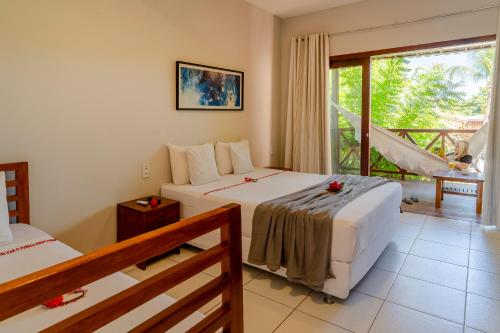 a bedroom with two beds and a balcony at Casa Suiça Brasileira in Jericoacoara