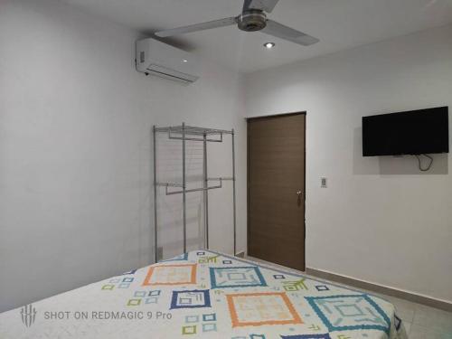 プエルト・バジャルタにあるDepartamento del Cualeのベッドと薄型テレビのある寝室