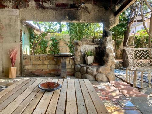 a patio with a wooden table and a stone fireplace at La villa au palmier - 10ch, 2sdb, toit terrasse in Perpignan