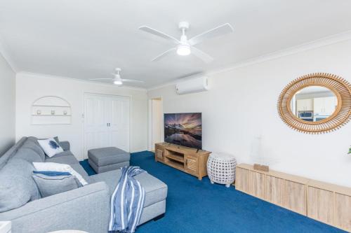 a living room with a couch and a mirror at The Observation Deck by Experience Jervis Bay in Sanctuary Point