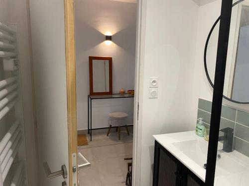 a bathroom with a sink and a mirror and a table at La villa au palmier - 10ch, 2sdb, toit terrasse in Perpignan