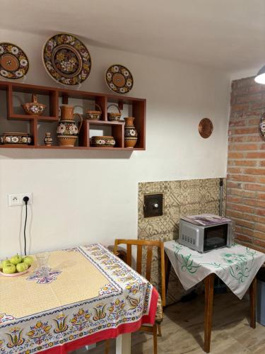 ein Esszimmer mit einem Tisch und einer Mikrowelle in der Unterkunft Apartment Klingerček in Banská Štiavnica