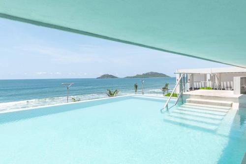 a swimming pool with a view of the ocean at Hermoso Depa lujoso Cristal Bay Sobre el Malecon in Mazatlán