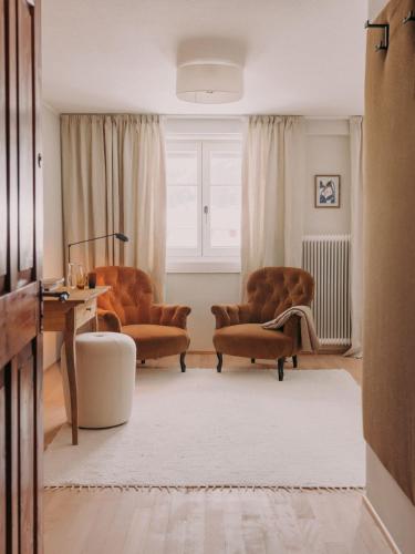 a living room with two chairs and a table at Sandbur Das Walserhaus in Lech am Arlberg
