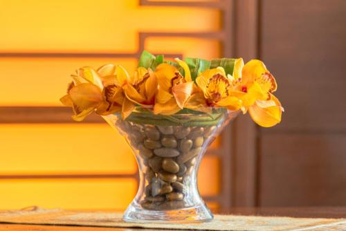 a vase filled with yellow flowers on a table at Britannia Suites in Beirut