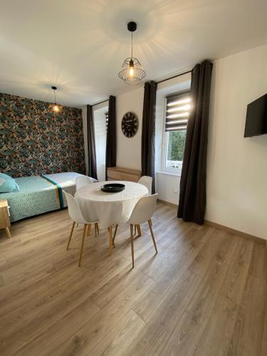 a room with a table and chairs and a bed at Studio 1er étage - Centre-ville - Local vélos disponible in Mayenne