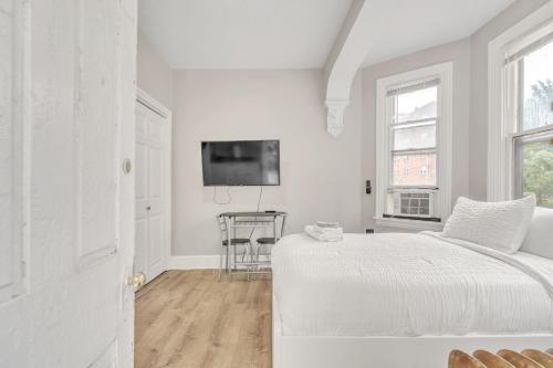 a white bedroom with a bed and a table at Trolley Teacup Charming Cozy Studio apts in Wilmington
