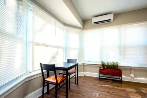 a room with a table and two chairs and windows at Gilpin Grand - Renovated space in Trolley Square apts in Wilmington