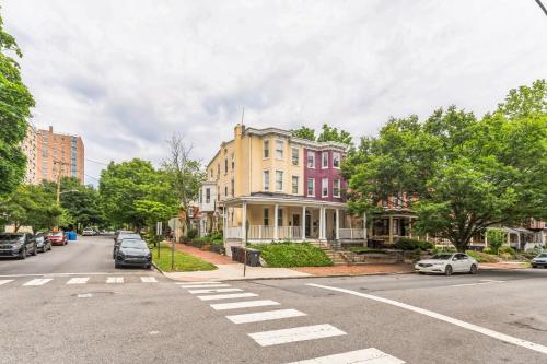 an intersection of a street with a yellow house and cars at Trolley Teacup Charming Cozy Studio apts in Wilmington