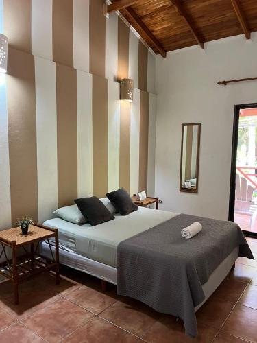 a bedroom with a bed with a striped wall at Point Break Santa Teresa in Santa Teresa Beach