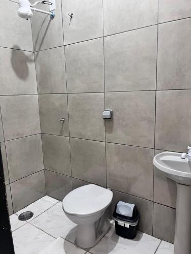 a bathroom with a toilet and a sink at Hotel Loren in Bauru