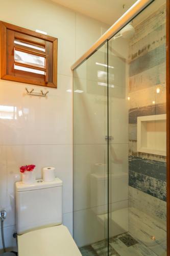 a bathroom with a toilet and a glass shower at Casa Suiça Brasileira in Jericoacoara
