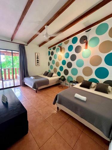 a bedroom with two beds and a wall with polka dots at Point Break Santa Teresa in Santa Teresa Beach