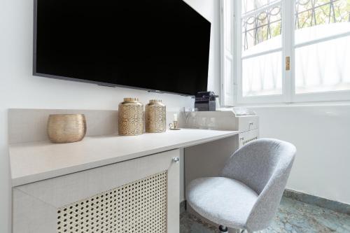 a living room with a tv and a chair at Duomo Smart Suites in Milan