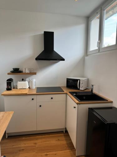 une cuisine avec des armoires blanches et un four à plaques de cuisson dans l'établissement Appartement calme et lumineux, à Fontainebleau