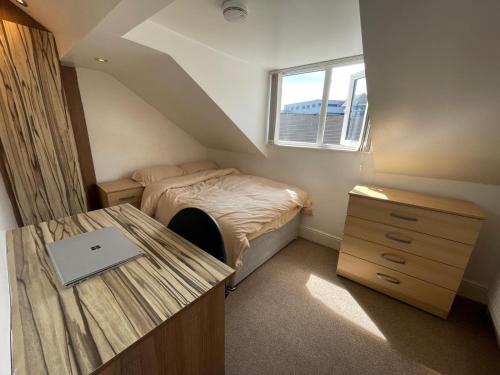 a bedroom with a bed and a desk and a window at Town centre, very convenient in Newcastle under Lyme