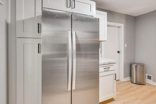 a stainless steel refrigerator in a kitchen with white cabinets at University of Akron Retreat Dogs Welcome! in Akron