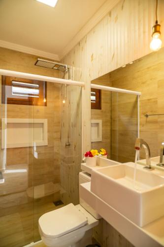 a bathroom with a sink and a toilet and a shower at Casa Suiça Brasileira in Jericoacoara