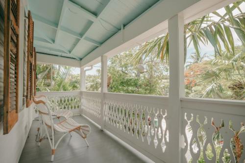 a porch with a rocking chair and windows at Winslow's Bungalows - Key West Historic Inns in Key West