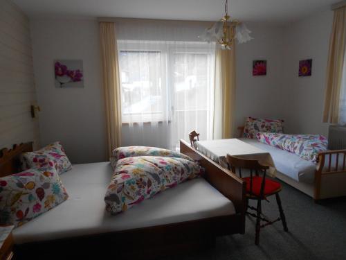 1 dormitorio con 2 camas, escritorio y ventana en Haus Leitgeb, en Telfes im Stubai