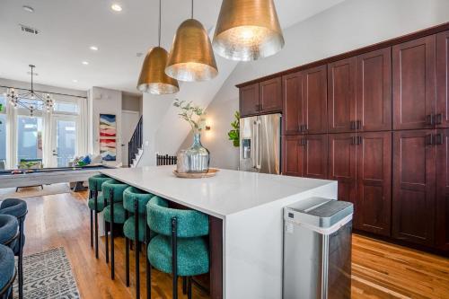 a kitchen with a large island with green bar stools at Luxury Downtown Getaway with Breathtaking Views in Houston