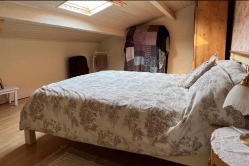 a bedroom with a bed with a white comforter at 4 bed home with private pool in Génouillé