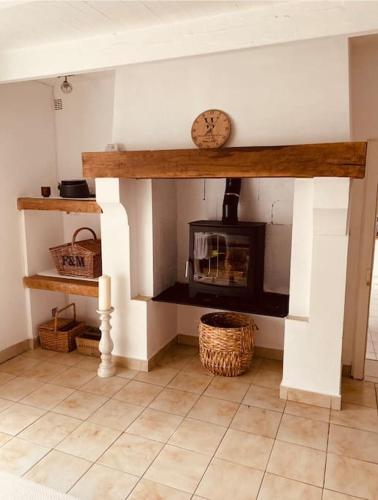 a living room with a fireplace in a house at 4 bed home with private pool in Génouillé