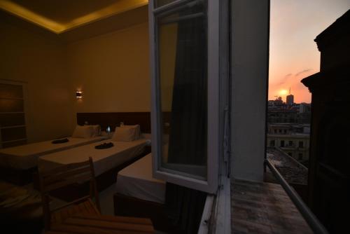 a room with two beds and a window with a view at family suites cairo downtown in Cairo