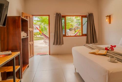 a bedroom with a bed and a sliding glass door at Casa Suiça Brasileira in Jericoacoara