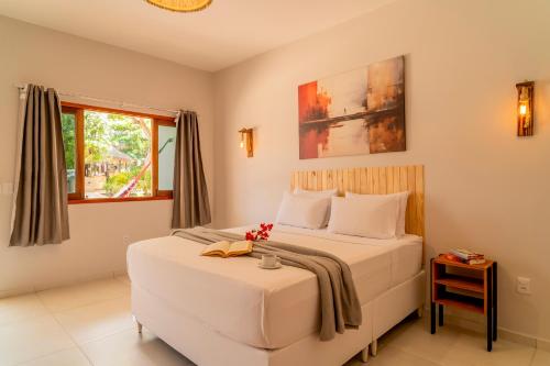 a bedroom with a large white bed and a window at Casa Suiça Brasileira in Jericoacoara