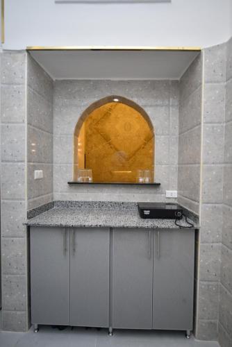 a kitchen with a counter and an arch in the wall at family suites cairo downtown in Cairo