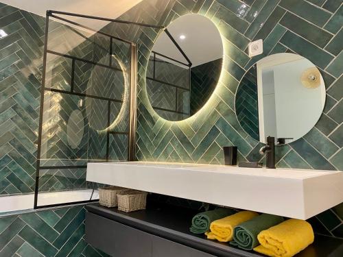 une salle de bain avec un lavabo et un miroir dans l'établissement Beau duplex marseillais très lumineux, à Marseille