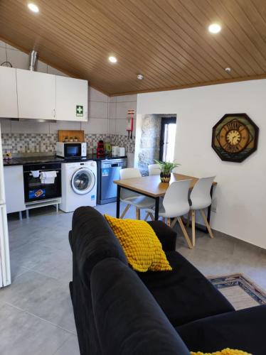 a living room with a couch and a table and a kitchen at Casa da Martha in Celorico da Beira