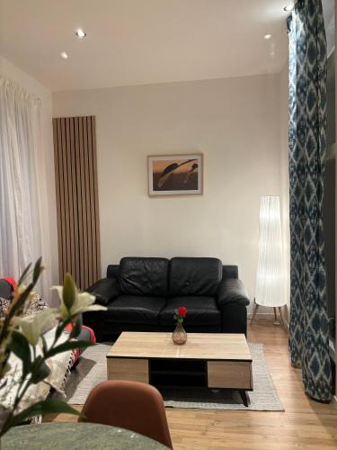a living room with a black couch and a coffee table at Astou Cisse in Marseille