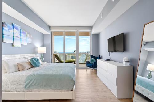 a bedroom with a bed and a flat screen tv at Ocean Views - Pool & Gym - Pet Friendly - Close to Beach in Hallandale Beach