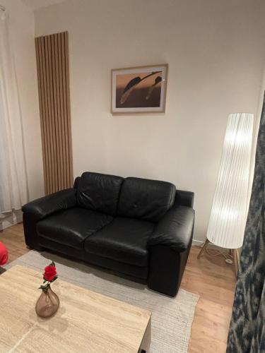 a black leather couch in a living room with a table at Astou Cisse in Marseille