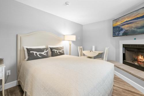 a white bedroom with a bed and a fireplace at Big Bear Frontier in Big Bear Lake