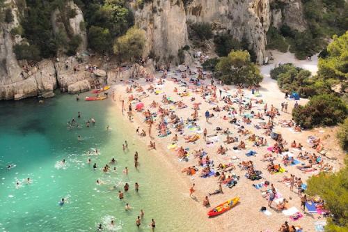 a crowd of people on a beach in the water at Astou Cisse in Marseille