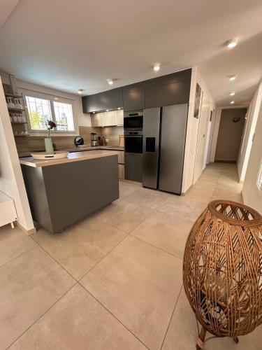 une grande cuisine avec des appareils en acier inoxydable et une table dans l'établissement Villa ELEMIAH, à Saint-Tropez