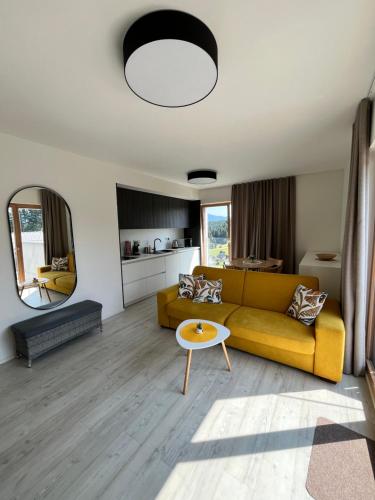 a living room with a yellow couch and a table at Hillside Y34 in Dolný Kubín