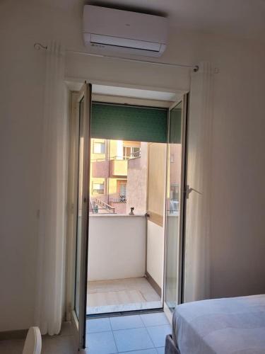 a bedroom with a door open to a balcony at Cavour3 in Nettuno