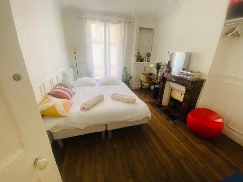 - une chambre avec un lit avec deux oreillers et un bureau dans l'établissement Chambre Paris Stade de France, à Saint-Denis