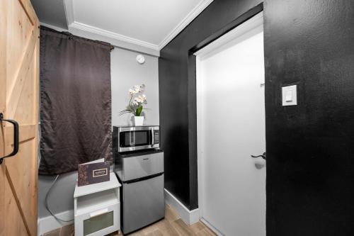 a small kitchen with a microwave on a counter at Charming Urban Studio Near Rice University & Museum District in Houston