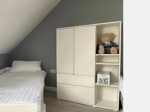 a white cabinet in a bedroom with a teddy bear at Leitrim Property Cork in Cork