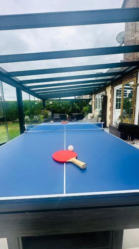 a blue ping pong table with a ping paddle on it at Entire guest suite with gated property in Broad Blunsdon