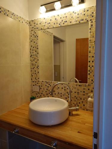 a bathroom with a white sink and a mirror at Km cero in Trevelín